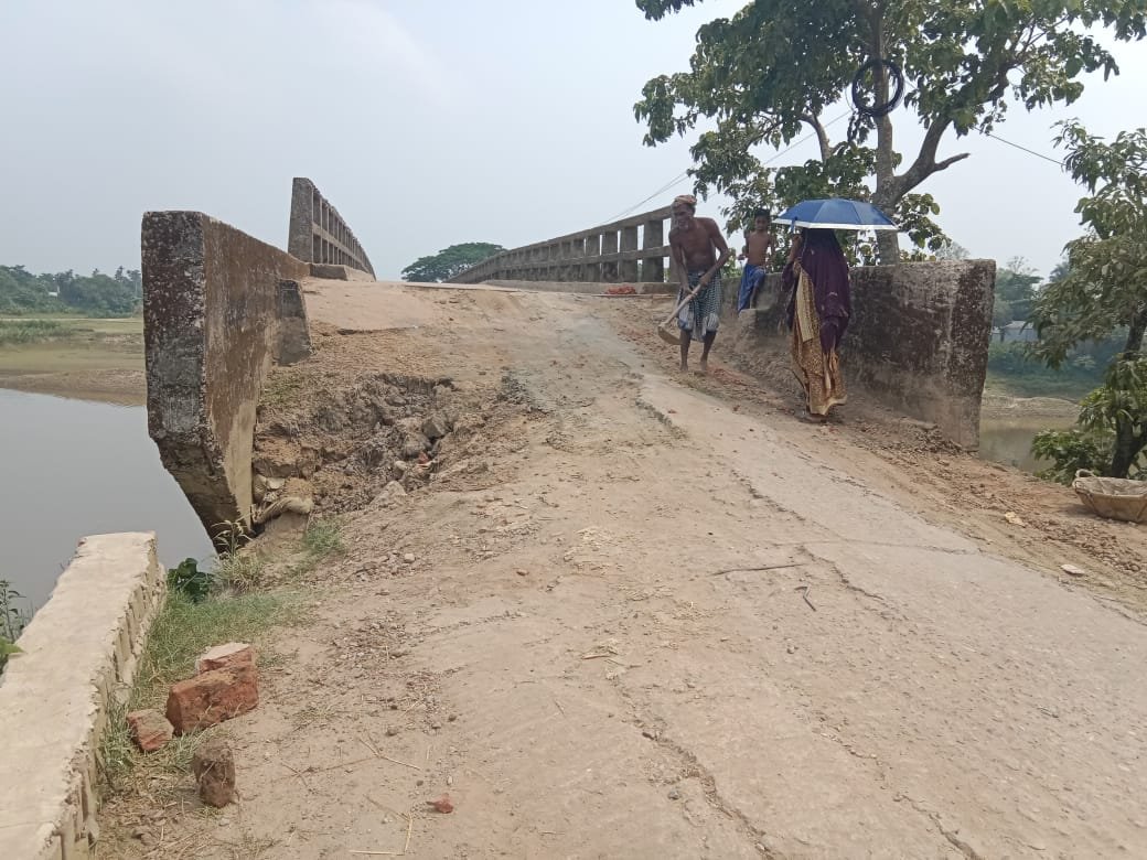 নিজের টাকায় ব্রিজের এপ্রোচ ও সড়কের খানাখন্দ ঠিক করেন দিনমজুর  মনাই মিয়া